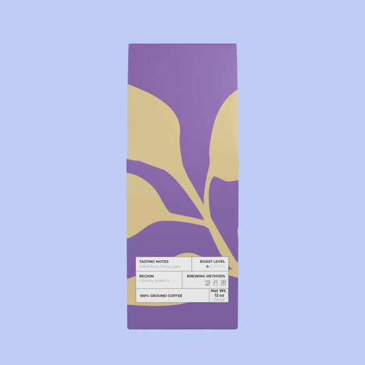 Purple coffee package with gold leaf design on a white background, light roast ground coffe 12 ounces